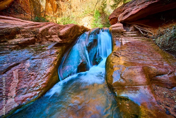 Fototapeta Waterfall Flow Over Red Sandstone Rocks in Kanarra Canyon Close Up Perspective