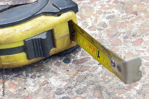 Obraz Close-up photo of an aged, rusted yellow measuring tape on a textured surface
