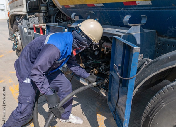 Fototapeta The technician is connecting an additional gas line from truck to supply gas to the bulk tank.