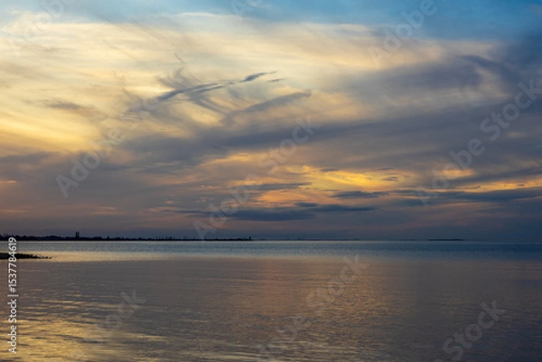 Fototapeta Beautiful cloudy evening sky over Cleveland Point, viewed across Moreton Bay, from Morwong Beach, Coochiemudlo Island. Queensland, Australia