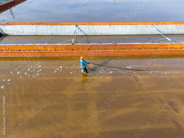Obraz Salt-farm workers produce salt in the salt fields， salt-farm equipment produces salt