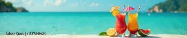 Fototapeta Two exotic fruit drinks with tiny umbrellas near the water's edge,  escape,  drink