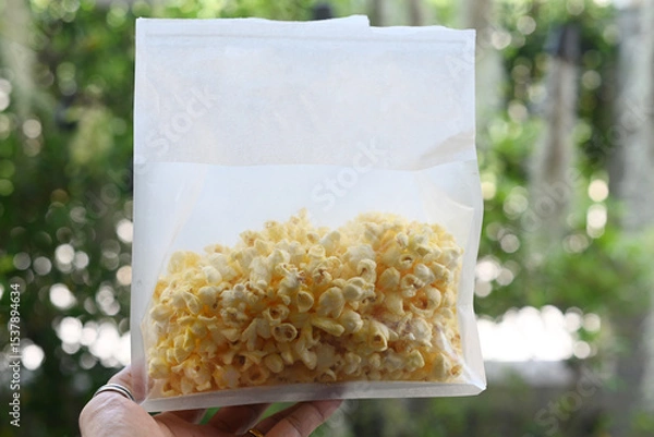 Fototapeta Butter-flavored popcorn in a white bag.