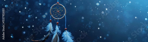 Fototapeta Dreamcatcher with feathers hanging under starry night sky with glowing bokeh lights