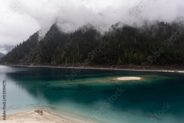 Fototapeta Jiuzhaigou, China: Dramatic view of the long lake on a foggy spring morning in the famous jiuzhaigou scenic area in the mountain of Sichuan in China