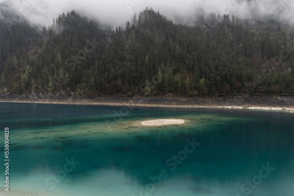 Fototapeta Jiuzhaigou, China: Dramatic view of the long lake on a foggy spring morning in the famous jiuzhaigou scenic area in the mountain of Sichuan in China