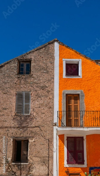 Obraz Corsica, France, Europe: a characteristic building in Corte, famous old village of the Haute Corse, with a facade divided between exposed stone and a plastered and orange painted section