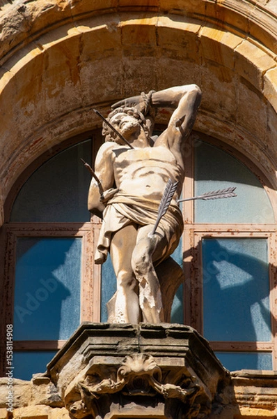 Obraz Donostia-San Sebastian, Spain: the statue of San Sebastian pierced by arrows on the facade of the Basilica of Saint Mary of the Chorus, baroque Roman Catholic parish church completed in 1774, one