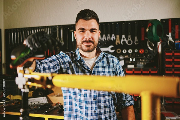 Obraz Bicycle mechanic repairing bike in workshop