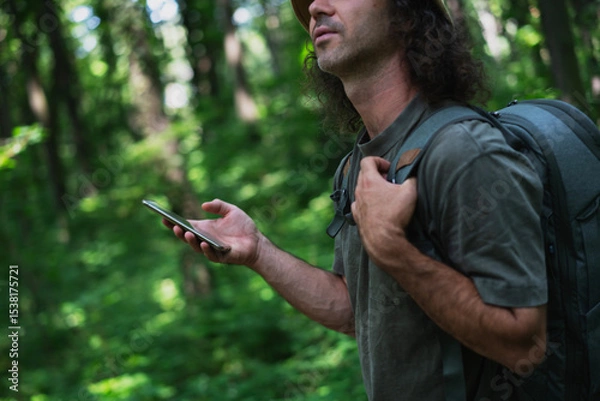 Fototapeta Man Using Smartphone in Forested Area