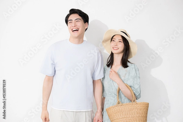 Fototapeta 夏のカップルでお出かけやレジャーやリゾート旅行、新婚旅行や夏休みのイメージの全身手を繋ぐ 白背景