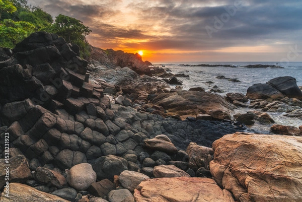 Fototapeta Panoramic landscape with basalt columns Ganh Da Dia on rocky beach by sea. Da Dia reef in Vietnam at sunrise