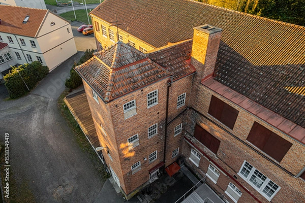 Fototapeta Aerial view of an old factory with large windows and vintage industrial architecture, showcasing unique historical design and brickwork from above