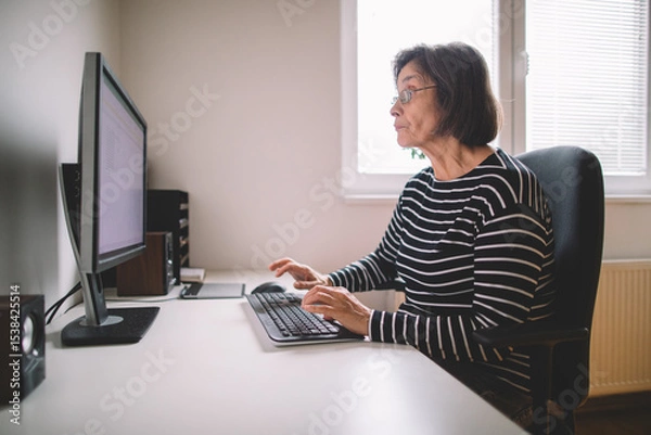 Fototapeta Senior woman working from home on the computer	