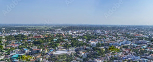 Fototapeta Cityscape view from top of the hill or mountain with white cloud and blue sky, view from top of Khao Sakae Krang mountain, Uthai Thani province, Thailand