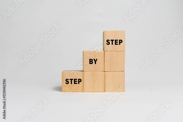 Fototapeta step by step word on wooden blocks staircase isolated on white background. concept of success progress or career