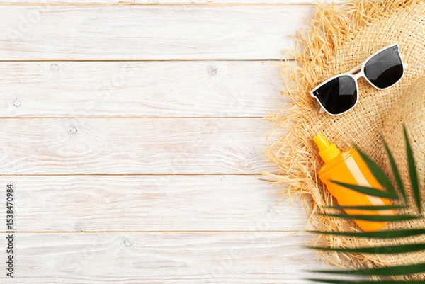 Obraz Vacation travel planning simple background of straw hat sunglasses palm leaves and sunblock lotion on white planks flat lay with copy-space