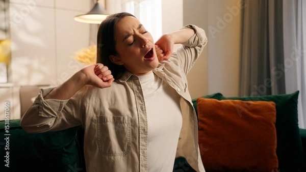 Fototapeta Portrait sleepy tired exhausted yawning Caucasian woman girl female lady feeling fatigue sitting at couch problem health napping yawn at home in living room stretching hands relaxation lazy boring