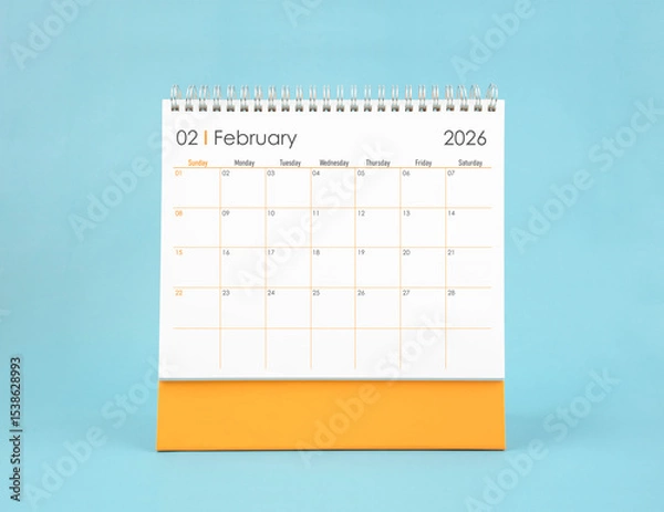 Fototapeta February 2026 white desk calendar on blue color background. Planning and goals concepts.