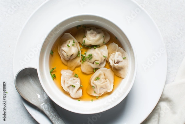 Obraz Overhead view of wonton soup in a white ceramic bowl, clear soup with dumplings in a white soup bowl