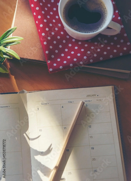 Fototapeta Calendar book for Planner to plan reminder daily appointment timetable, appointment, organization, and meeting agenda of job on wooden desk, work from home-vertical image.