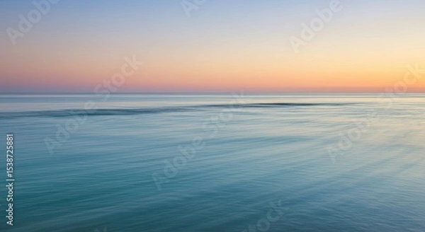 Fototapeta Serene ocean view at sunrise with calm water reflecting the vibrant sky colors.