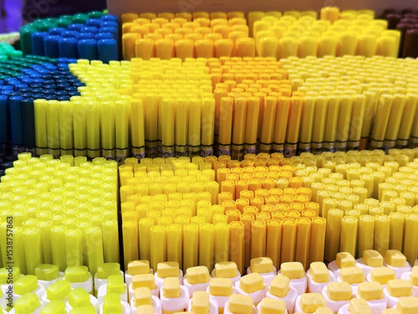 Fototapeta Colorful arrangement of various crayons in vibrant shades of yellow, blue, and green. The scene showcases a creative and artistic concept.