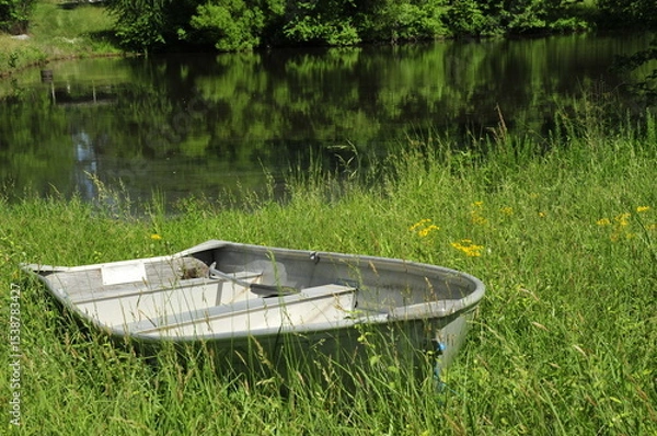 Fototapeta Row boat in tall grass by lake