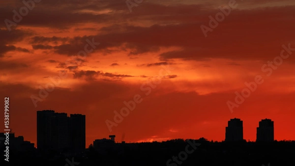 Obraz Silhouette of constructing buildings against amazing sunset red sky.
