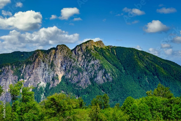 Fototapeta 2025-06-03 VIEW OF MOUNT SI WITH LUSH TREES AND EXPOSED ROCK ON THE SIDE OF THE MOUNTAIN WITH A NICE SKY IN NORTH BEND WASHINGTON