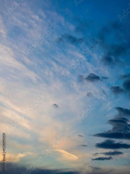 Obraz Vertical cloudscape at sunset early in May, southwest Florida, with high diaphanous clouds in the distance and darkening cloudlets in foreground. Motifs of duality, transition, and change in nature.