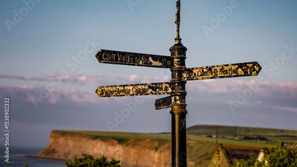 Fototapeta Old metallic signpost showing directions to different places in Saltburn by the Sea, UK