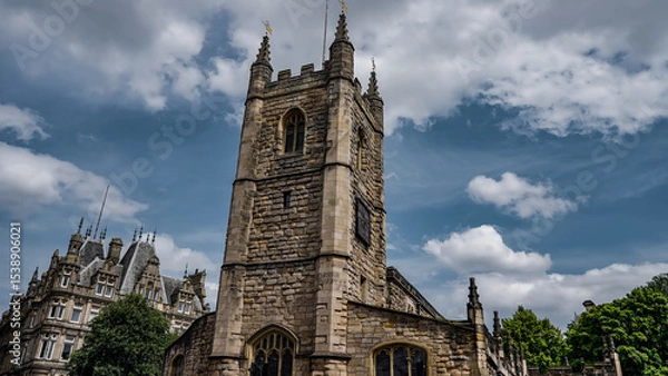 Fototapeta St. Nicholas Cathedral's stone tower standing tall against a backdrop of dynamic clouds in Newcastle upon Tyne, UK