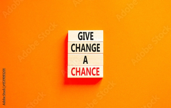 Fototapeta Give change a chance symbol. Concept words phrase Give change a chance on beautiful wooden blocks. Beautiful orange paper background. Business Give change a chance concept. Copy space.