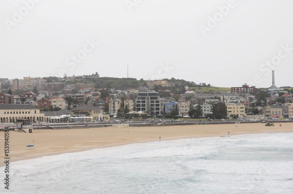 Fototapeta Serene Bondi Beach and architecture under cloudy sky, Australia