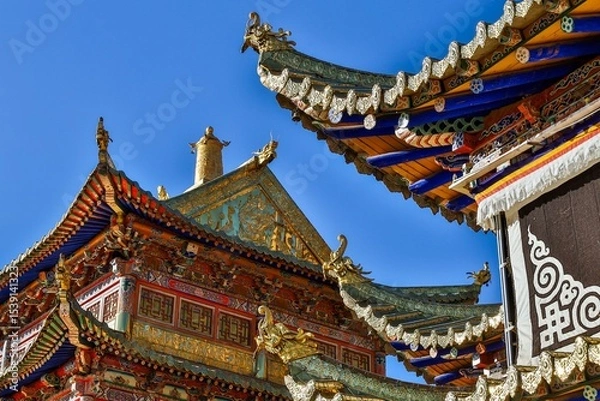 Fototapeta Intricate Tibetan architecture details of Taktsang Lhamo Monastery (Langmusi), a sacred Buddhist site in the Amdo region, showcasing vibrant ornamentation and traditional roof design.