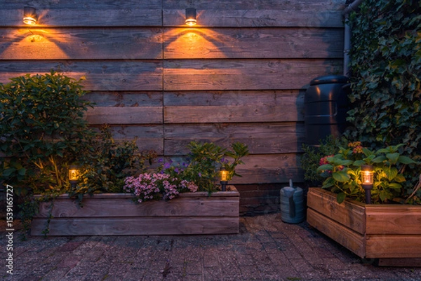 Obraz Solar-powered outdoor lighting illuminating a garden with flowers and plants. 