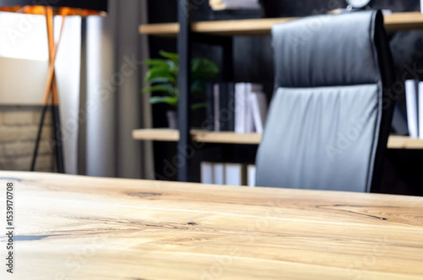 Fototapeta Modern business office with leather chair and wooden desk in front of elegant bookshelf with decor and books. Workspace interior for executive or entrepreneur