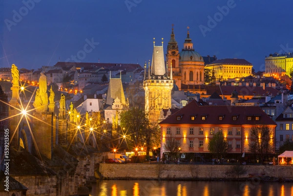 Fototapeta Evening view of Charles Bridge and Old Town in Prague, Czech Republic with illuminated buildings and river reflections