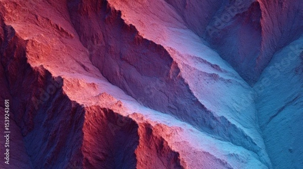 Fototapeta Abstract aerial view shows rocky terrain with colorful lighting. Dramatic landscape, geological formation, desert canyon, scenic travel, arid environment, unique geology.