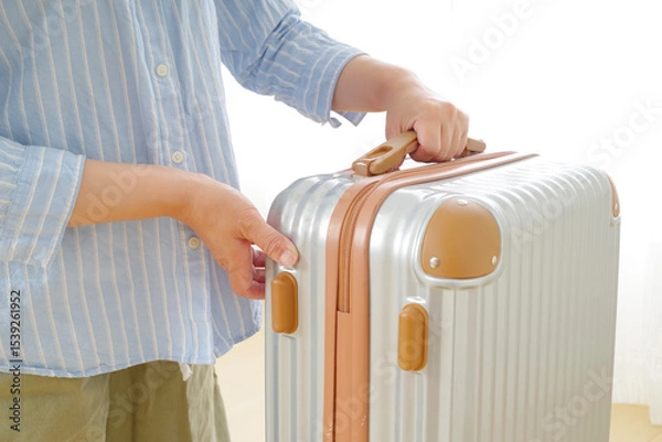 Obraz 旅行バッグを持つシニア女性の手元