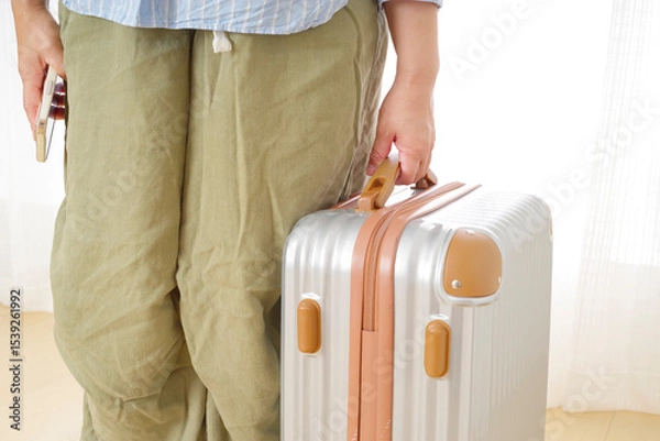 Obraz 旅行バッグを持つシニア女性の手元