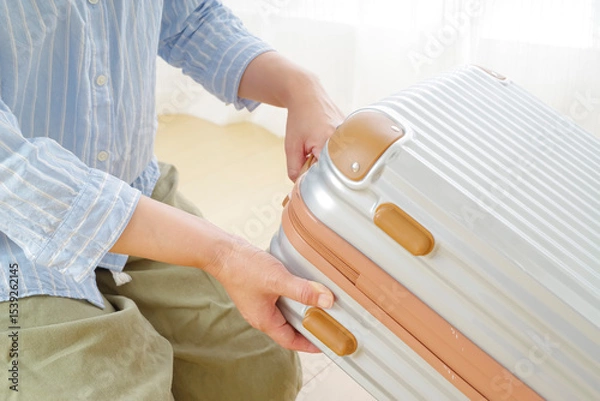 Obraz 旅行バッグを持つシニア女性の手元