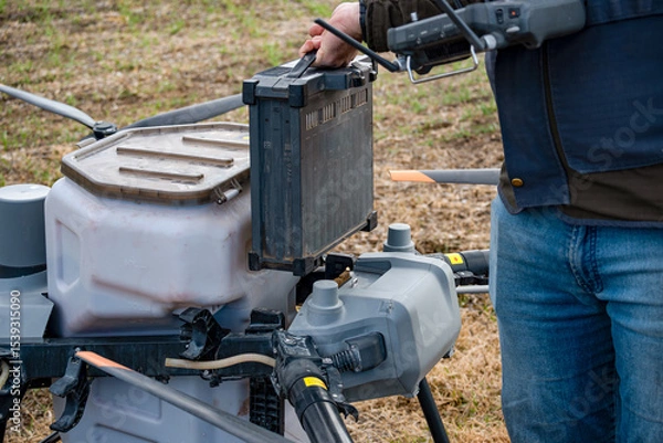 Fototapeta Agricultural technicians replace the battery of a large agricultural drone. Smart farm concept with agricultural technology.