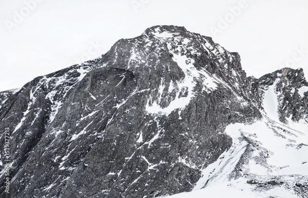 Obraz A majestic mountain peak covered in snow against a bright white sky on a cold winter day scene view