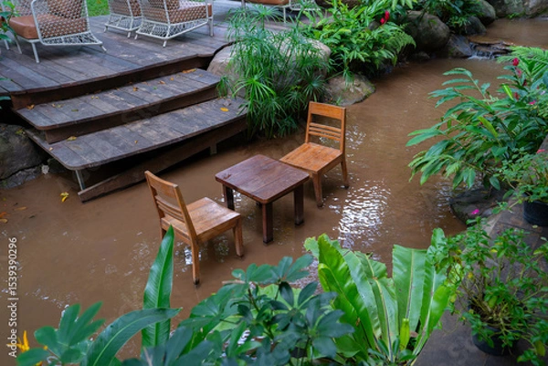 Obraz Wooden chairs and table in flooded garden setting create unique and tranquil atmosphere