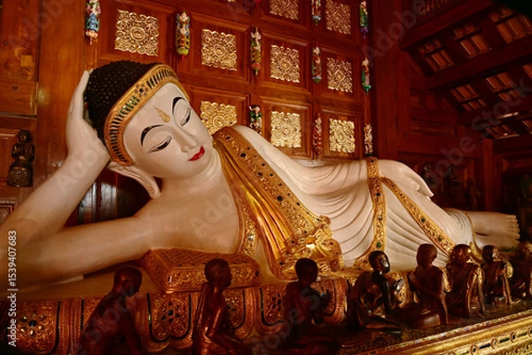 Obraz The Reclining white statue Buddha is enshrined in a teakwood chapel at Wat Den Sali Si Mueang Kaen temple or Wat Ban Den. Located at Cheng Mai Province in Thailand.