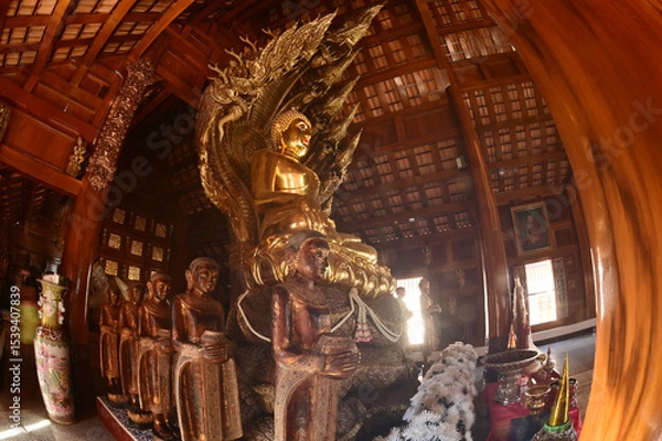 Obraz Golden sitting Buddha statue and there is a serpent covering the back in Buddhist Thai Church at Wat Den Sali Si Mueang Kaen temple. Located at Chiang Mai city in Thailand.