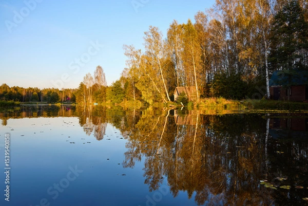 Obraz Tranquil Reflections: House and Trees Mirrored in River