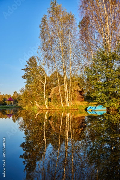 Obraz Tranquil Reflections: House and Trees Mirrored in River